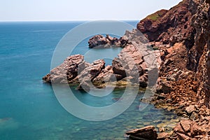 Adriatic sea red rocks coast.