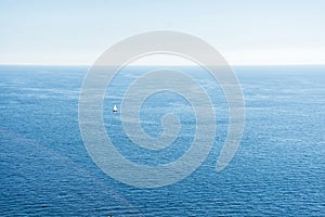 Adriatic sea view with a small boat with white sail. Calm seascape and clear blue sky