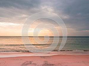 Adstract color of pink beach in golden sunset at the beach. dramatic gray cloudy sky above sea water