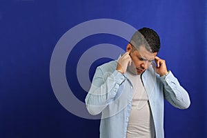 Adult 40-year-old brown Latino man suffers from pain in the ears due to otitis, hypocausia or vertigo