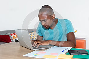 Adult african american man with concentration at work with computer