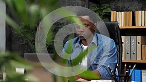 Adult African American man freelancer works for laptop typing text on keyboard