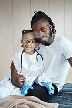 Adult African American man hugging a little girl