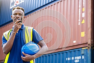 Adult African american men worker Check and control loading freight Containers by use radio at commercial shipping dock