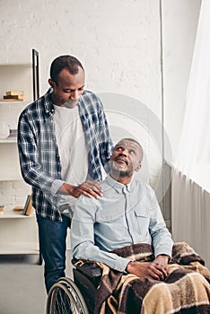 adult african american son looking at disabled senior father photo