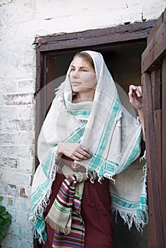 A woman in ancient clothes is standing at the door