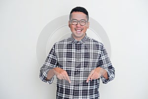 Adult Asian man showing excited expression while pointing below photo