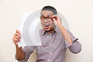 Adult Asian man showing excited expression when read a letter