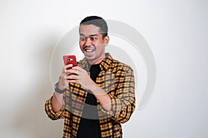 Adult Asian man showing surprised face expression while read message in his mobile phone