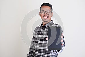 Adult Asian man wearing glasses showing blank mobile tablet screen photo