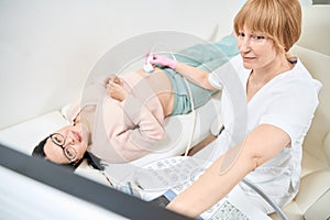 Adult asian woman getting first trimester ultrasound to check the pregnancy