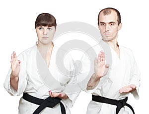 Adult athletes with black belts are doing block Shuto-uke photo