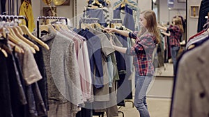 Adult attractive woman taking photos of clothes in a clothing store on her smartphone camera