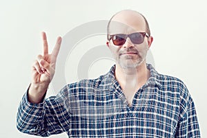 Adult bald man with a gray beard wearing sunglasses checkered sh