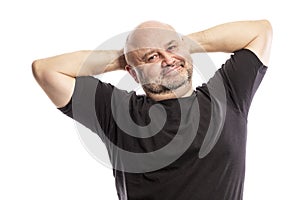 Adult bald man with hands behind his head is smiling. Isolated on a white background