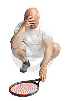 Adult bald man in sportswear with a tennis racket in his hand. Defeat and annoyance. Isolated on a white background. photo