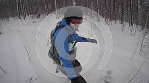 Adult bearded man quickly and actively driving on snowy trail somewhere in the woods. He`s a little tired, but it is