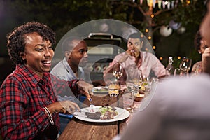 Adult black family enjoy dinner and conversation in garden