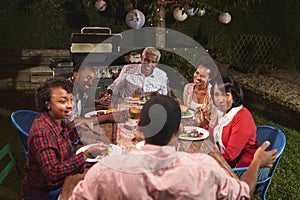 Adult black family talking at dinner in their garden