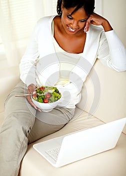 Adult black woman eating healthy green salad