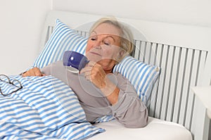 Adult Blond Woman on her Bed Holding her Cup