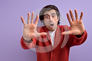 Adult brunette man over isolated background doing stop gesture with fear expression