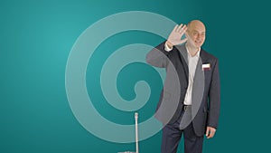 Adult business man with suitcase waving hand on green background