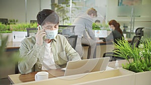 An adult businessman is talking with someone on the phone during working