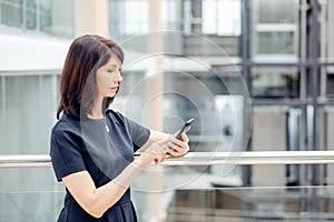 Adult businesswomen in suit using smartphone