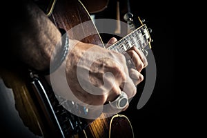 Adult caucasian guitarist portrait playing electric guitar on grunge background. Close up instrument detail. Music
