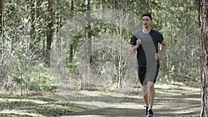 Adult caucasian strong sportsman is jogging on the track at the park preparing to workout