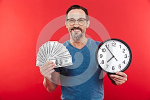 Adult cheerful positive man holding money and clock.