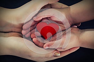 Adult and child hands holding red heart, health care, donate and family insurance concept,world heart day, world health day, CSR c