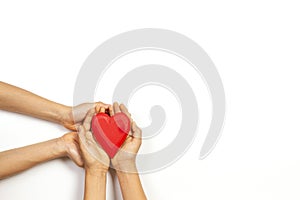 Adult and child hands holding red heart over white background. Love, healthcare, family, insurance, donation concept