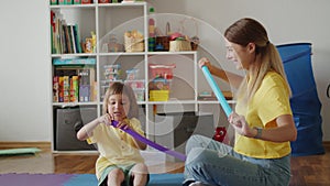 Adult and child happily playing with a sensory tube toy in a playroom. Joyful interaction and sensory stimulation
