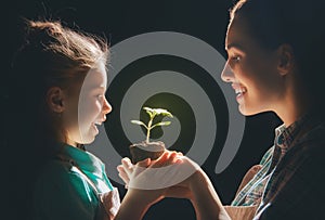 Adult and child holding green sprout.