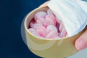 Adult child pink candy treats in powdered sugar from box