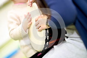 An adult and a child are playing a musical instrument. African djembe Meinl. Shallow depth of field