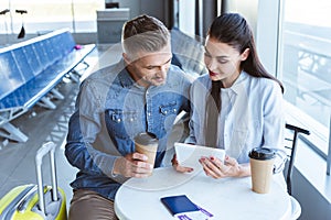 adult couple drinking coffee and using digital tablet