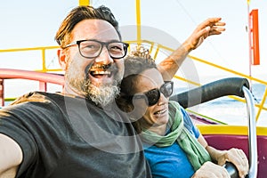 Adult couple have fun together on a roller coaster in amusement park taking selfie picture with the phone. People enjoying holiday