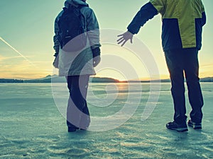 Adult couple holding hands walking on winter beach