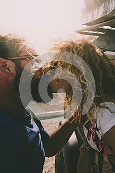 Adult couple in love kiss outside the car and travel together - concept of free and happy lifestyle for beautiful people traveling