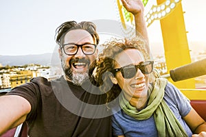 An adult couple of man and woman show expressions and fun during an extreme roller coaster ride. Smiling people have fun at