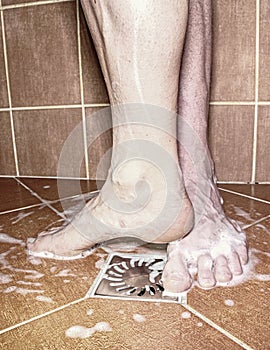 Couple playing in shower, feet on rural floor