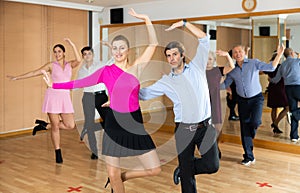 Adult couple practicing vigorous lindy hop in dance class
