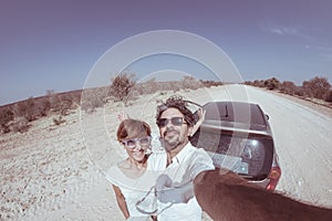 Adult couple selfie on road trip in the desert, Namib Naukluft National Park, travel destination in Namibia, Africa. Fisheye, peop