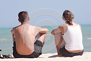 Adult couple sitting on the beach