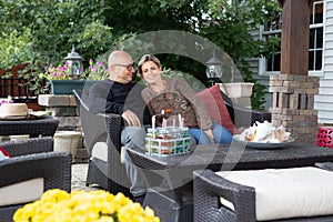 Adult couple sitting on couch at patio