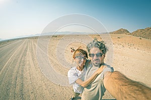 Adult couple taking selfie on road in the Namib desert, Namib Naukluft National Park, main travel destination in Namibia, Africa.