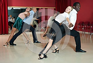 Adult couples dancing active dance together in modern studio